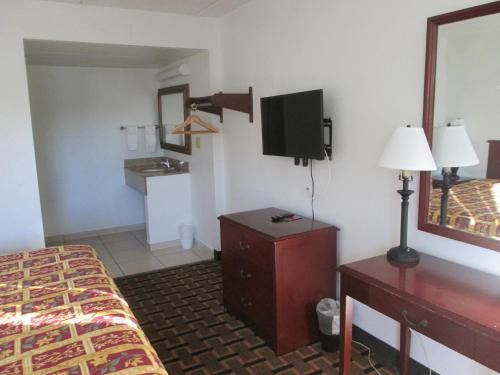 a hotel room with a bed and a tv at Budget Inn in Cocoa