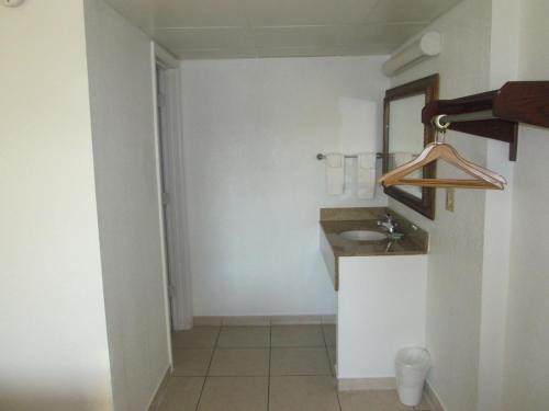 a bathroom with a sink and a mirror at Budget Inn in Cocoa