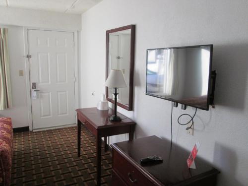 a hotel room with a flat screen tv on the wall at Budget Inn in Cocoa