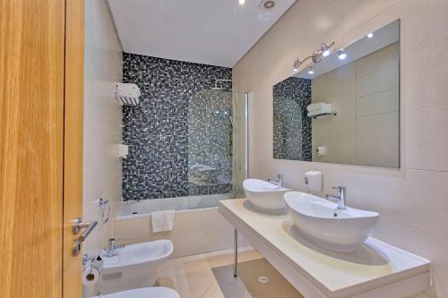 a bathroom with two sinks and a mirror at Colina Verde Resort in Moncarapacho