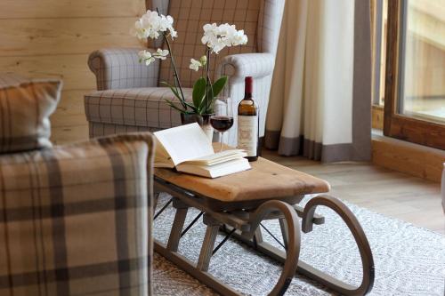 a table with a bottle of wine and a glass at Almlodge Westendorf in Westendorf