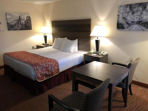 a hotel room with a bed and a table and chairs at MHO INN and SUITES in Monmouth Junction