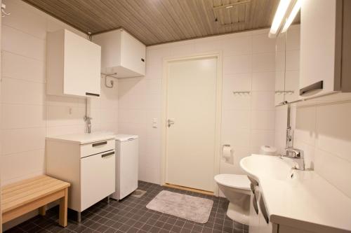 Baño blanco con lavabo y aseo en Kansankatu Apartments, en Rovaniemi