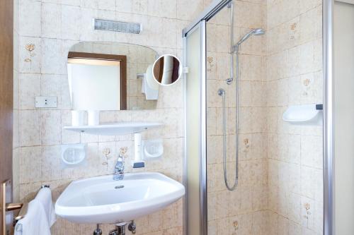 a bathroom with a sink and a shower at Hotel Tirolerhof in Brunico