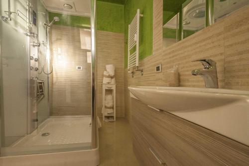 uma casa de banho com uma banheira, um lavatório e um chuveiro em Rogiual em Roma
