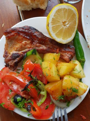 a plate of food with meat and vegetables on a table at Guest House Kusika in Sighnaghi