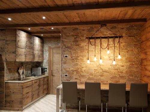 a kitchen with a stone wall and a table with chairs at Chalet Dcb in Bormio