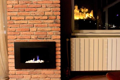 a brick wall with a fireplace next to a window at Penthouse Apartment 401 in Tbilisi City