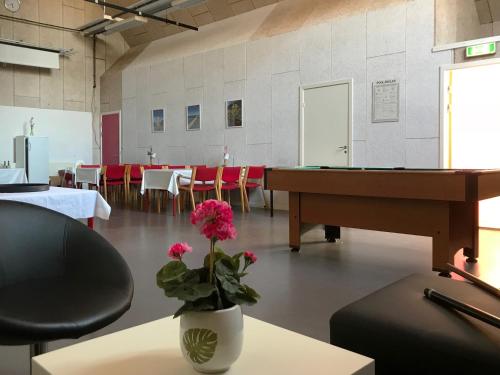a room with a table and a vase with a flower at Oasen Samsø in Nordby