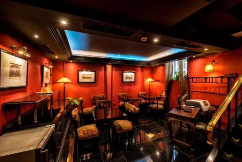 a restaurant with red walls and tables and chairs at Maison Grecque Hotel Extraordinaire in Patra