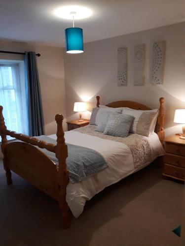 a bedroom with a bed and two lamps and a window at Swinford Bridge Street Apartment in Swinford