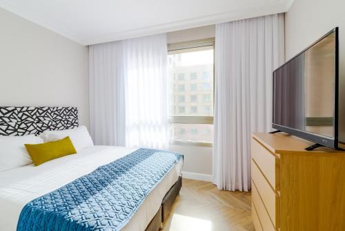 a bedroom with a bed and a flat screen tv at master Haifa in Haifa