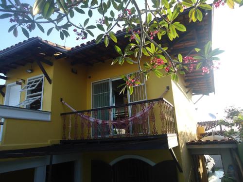 カボ・フリオにあるVila do Sossegoの黄色の家 花の咲くバルコニー付