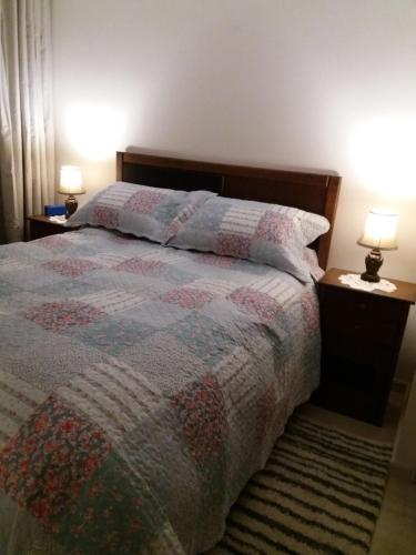 1 dormitorio con 1 cama con 2 mesitas de noche y 2 lámparas en Departamento frente al mar, en La Serena