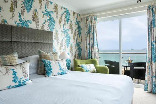a bedroom with a bed with a view of the ocean at Carbis Bay and Spa Hotel in St Ives