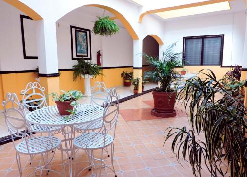 un patio con mesa, sillas y macetas en Hotel Valladolid, en Valladolid