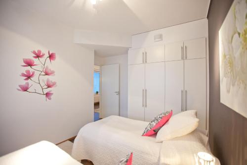 a bedroom with a bed and a flower on the wall at Joutsen Apartments in Rovaniemi
