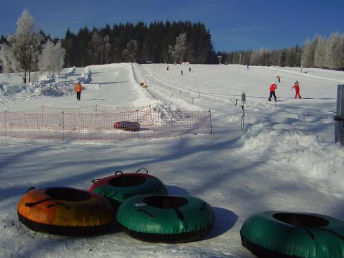 a group of people skiing down a snow covered slope at Pension Pugner in Vysoké nad Jizerou