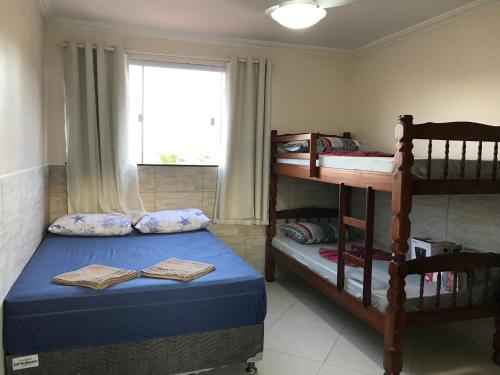 1 dormitorio con 2 literas y ventana en AP Agatha, en Arraial do Cabo