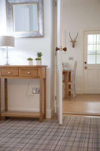 a room with a desk and a mirror and a table at The Gardener's Cottage in Dunblane