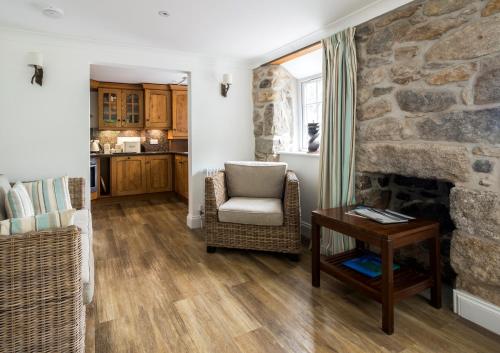 a living room with a chair and a stone fireplace at Carbis Bay and Spa Hotel in St Ives