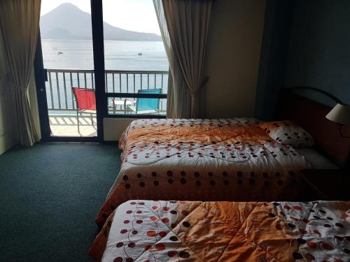 a hotel room with two beds and a view of the ocean at Sky View Atitlán Lake Suites - Free Breakfast Supplies in Panajachel