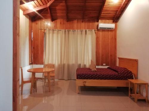 a bedroom with a bed and a table at Hotel El Congo in Drake