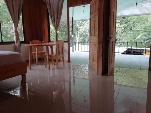 a dining room with a table and chairs and glass doors at Hotel El Congo in Drake