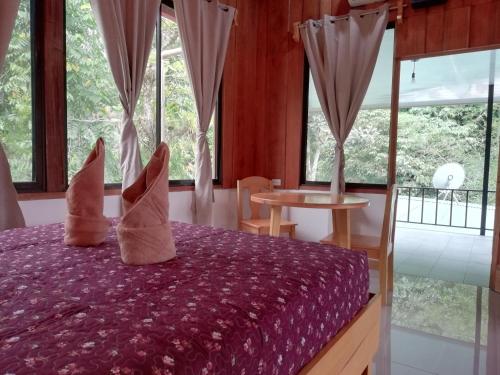 a bedroom with a purple bed with pillows on it at Hotel El Congo in Drake