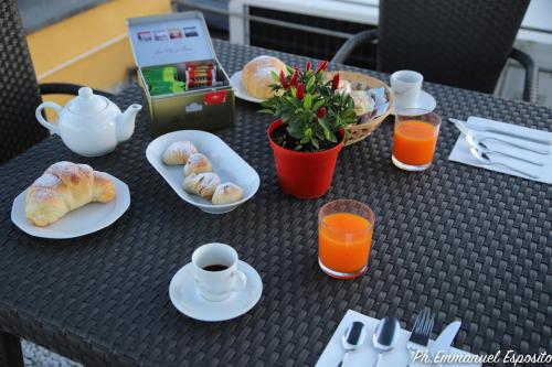 a table with plates of food and cups and orange juice at B&B Nel Regno di Napoli in Naples