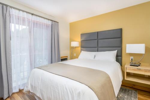 a bedroom with a large bed and a large window at Grey Fox Inn in Stowe