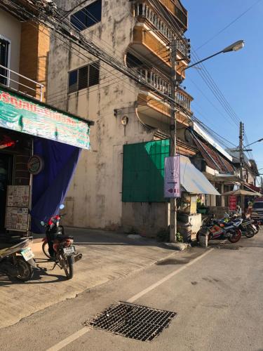 a motorcycle parked next to a building on a street at Rabbit Hotel in Phetchabun
