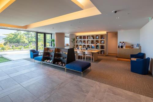 a living room with a table and blue chairs at JR Clement Inn Takamatsu in Takamatsu