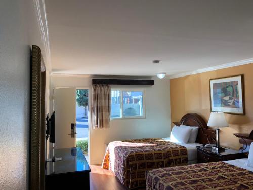 a hotel room with two beds and a window at Valley Hotel in Rosemead