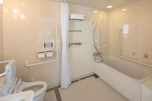 a bathroom with a toilet and a tub and a shower at JR Clement Inn Takamatsu in Takamatsu