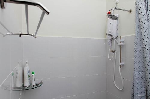 a bathroom with a shower with a blow dryer at KC Beachfront in Marang