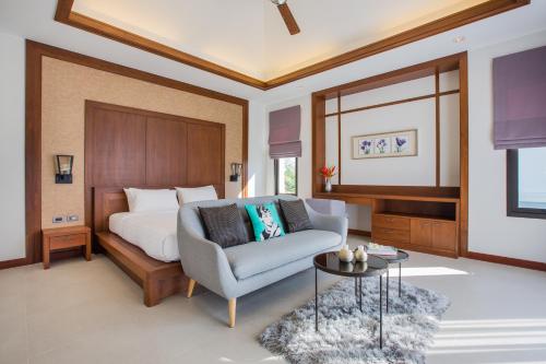 a bedroom with a bed and a couch and a table at Villa Palavee (A2) in Ao Nang Beach