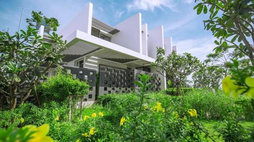 a building with a garden in front of it at Villas at Oceanami Resort in Long Hai