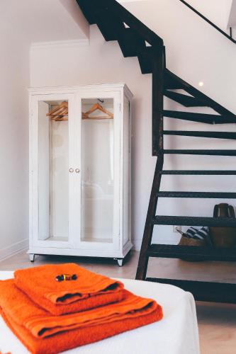 a room with a staircase and orange towels on a bed at Studio Sal in Albufeira