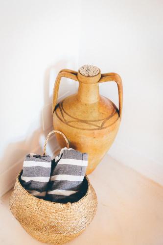 a vase sitting on a table next to a basket at Studio Sal in Albufeira