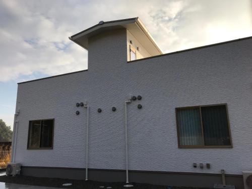 a white building with a window on top of it at UOGASHI 7070 Ocean View in Naoshima