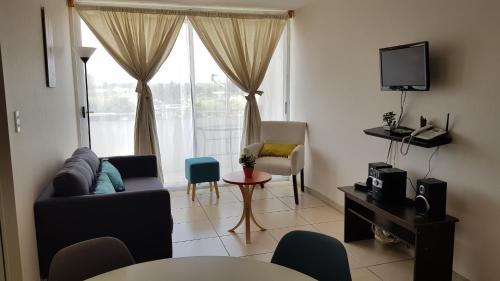 sala de estar con sofá y ventana en Condominio Costanera del Mar, en La Serena