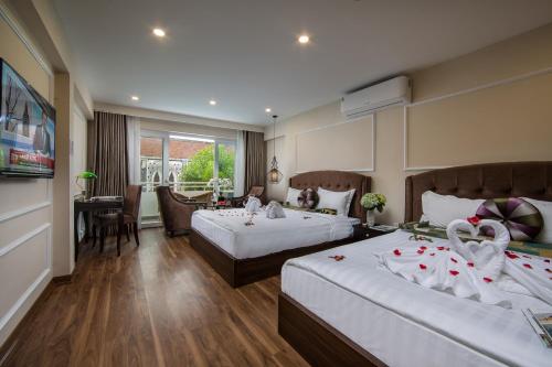 a hotel room with two beds with swans on them at Splendid Pearlight Hanoi in Hanoi