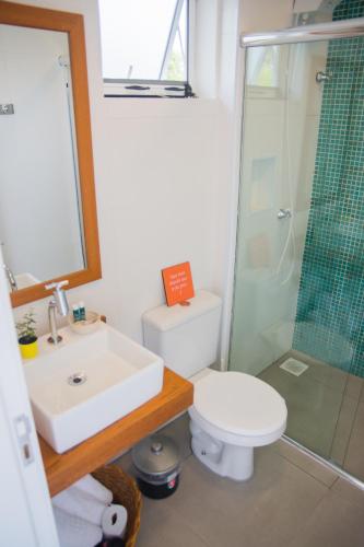 a bathroom with a sink and a toilet and a shower at Pousada Rosa Tropicalia in Praia do Rosa