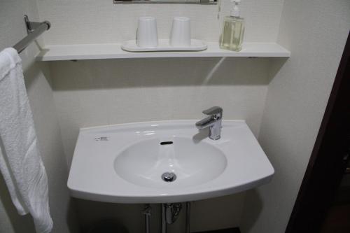 a white sink in a bathroom with a shelf at Hotel Grand Toya in Lake Toya
