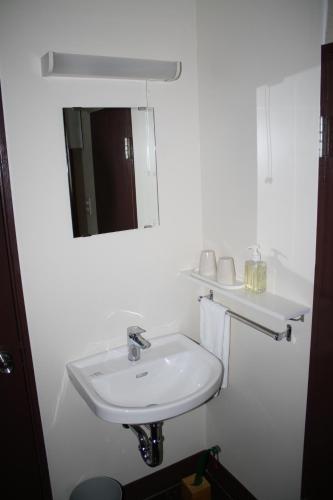 a white bathroom with a sink and a mirror at Hotel Grand Toya in Lake Toya