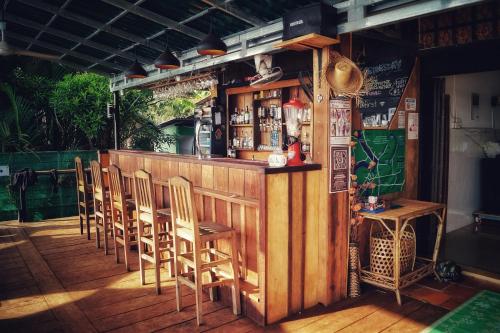a bar with wooden chairs and a counter with alcohol at The Hideaway in Kampot