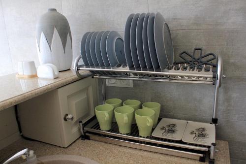a group of green cups on a shelf in a bathroom at Penthouse Apartment 401 in Tbilisi City