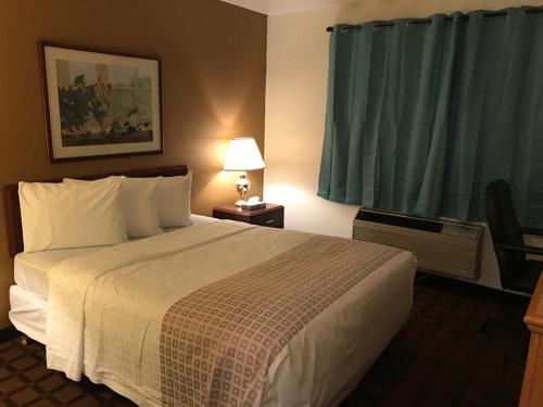una camera d'albergo con letto e finestra di Valued Stay Sun Prairie a Sun Prairie