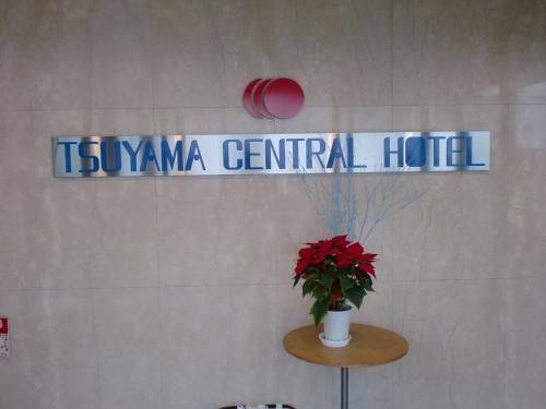 a sign for a centennial hotel with a vase of flowers at Tsuyama Central Hotel Townhouse in Tuyama